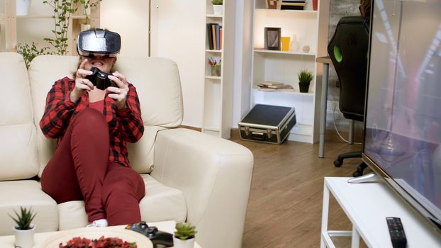 Young woman wearing vr headset while playing video games. Boyfriend sitting on gaming chair.