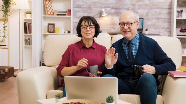 Couple of old people using modern technology. They are on a video call using laptop