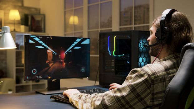 Male with headphones playing online video games talking with other players. Game over for man playing games sitting on gaming chair.