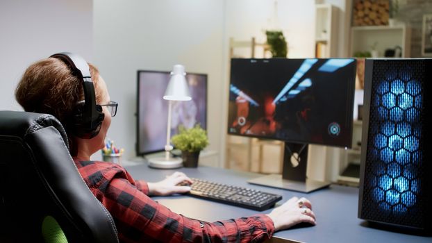 Woman with red hair upset she lost on a shooter online game sitting on gaming chair with headphones on.