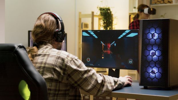 Man keeping his head on desk after losing at video games on computer. Game over for male gamer.