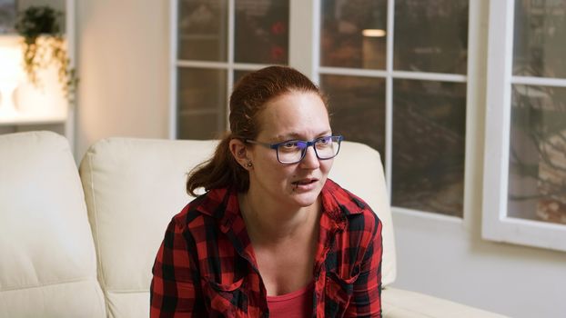 Upset woman keeping hands on her forehead after losing on video games.