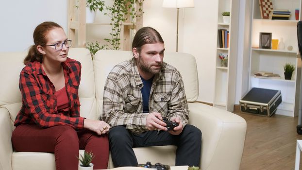 Man yelling at his girlfriend after losing while playing video games. Man using wireless controller.