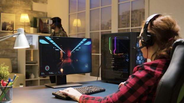 Woman with headphones relaxing playing computer games. Man experiencing virtual reality.