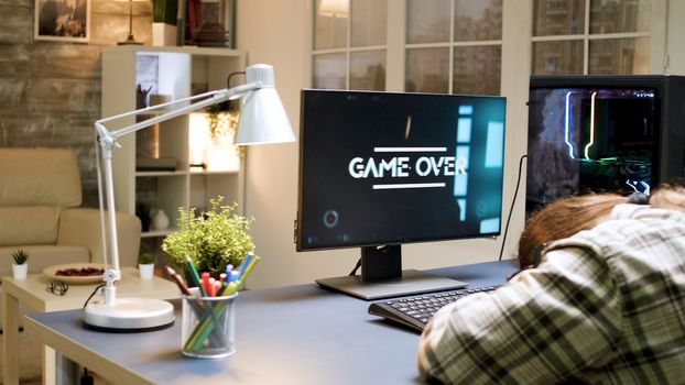 Man losing at shooter game while sitting on gaming chair. Woman with vr headset.