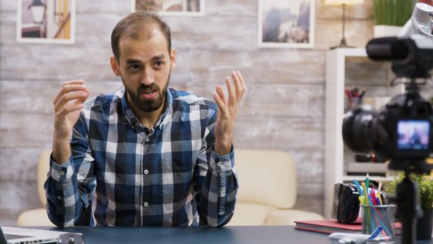 Angry young vlogger while recording a new podcast for his audience on social media. Famous influencer.