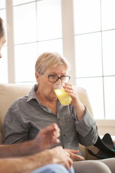 Portrait of senior woman in nursing home drinking her medicine.