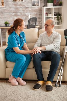 Female doctor in nursing home talking with male suffering of alzheimer.