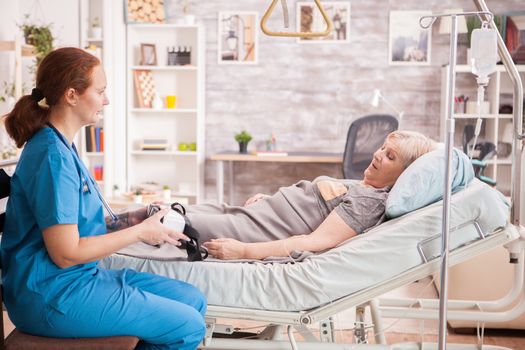 Female doctor showing senior woman vr headset in nursing home.