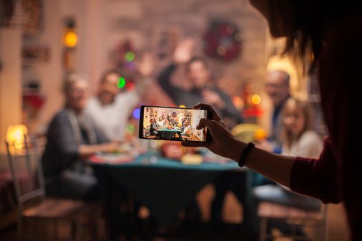 Girl using smartphone to take photos of her family for christmas celebration.