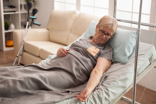 Retired old woman resting in bed in a nursing home. Peaceful retirement.