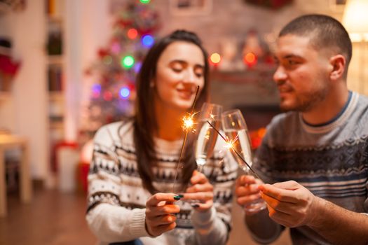 Loving couple holding hand fireworks on christmas day.