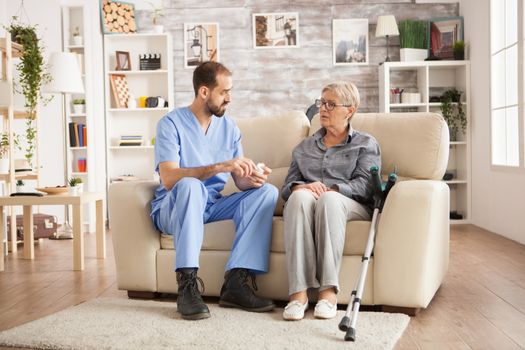 Doctor in nursing home talking with senior woman about her new pills.