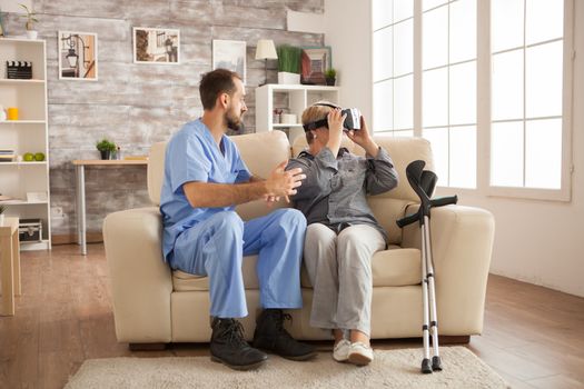 Cheerful senior woman in nursing home using vr headset.