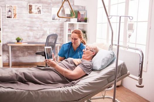 Female nurse showing medical report to senior woman in nursing home.