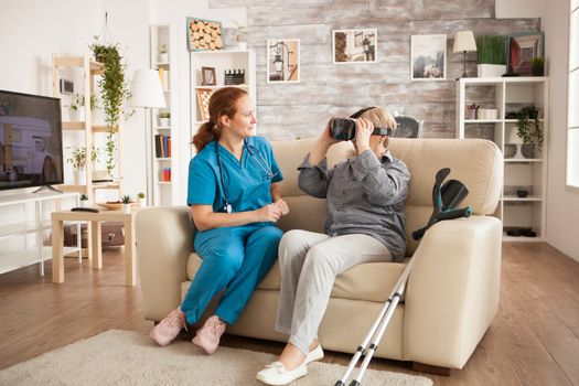 Female doctor with stethoscope and old woman using vr headset.
