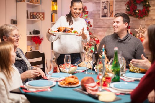 Excited woman with delicious chicken at christmas family dinner.