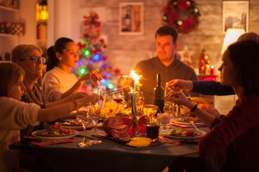 Happy family celebrating christmas holiday with sparkles and delicious food.