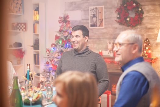 Cheerful caucasian man at christmas dinner with his family .