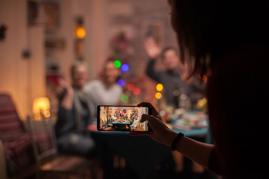 Granddaughter taking photos of her family at christmas celebration.