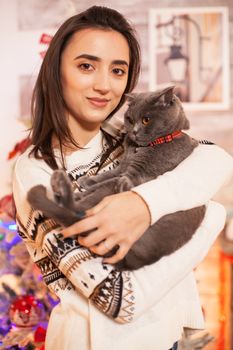 Portrait of happy girl holding her cat on christmas day.