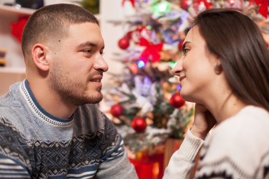 Happy girl looking at her handsome boyfriend celebrating christmas.