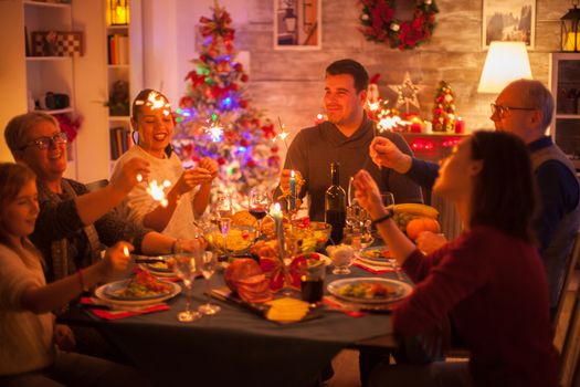 Big happy family celebrating christmas with delicious food and sparkles.