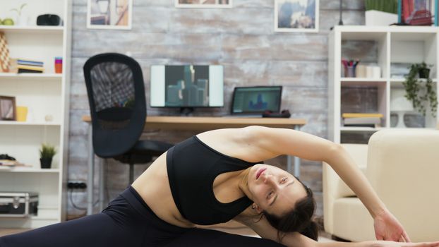 Carefree caucasian woman reaching for her foot in yoga pose.