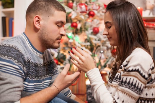 Loving couple in front of christmas tree. Happy holiday.