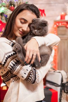 Happy girl giving affection to her cat on christmas day.