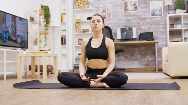 Caucasian young woman relaxing in home doing yoga. Woman taking care of her body.