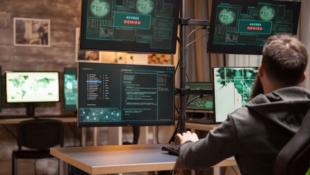Back view of male hacker gets access denied while trying to plant a malware.