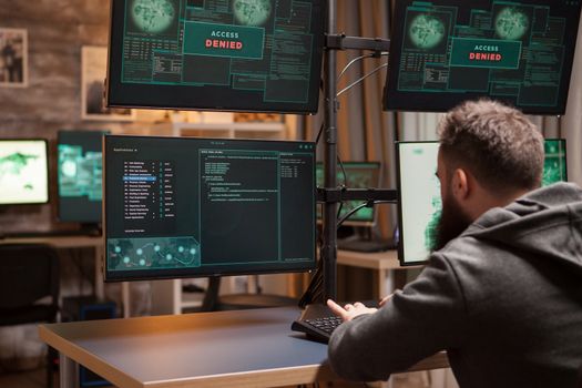 Bearded programmer hacking trying to steal information. Dangerous hacker.