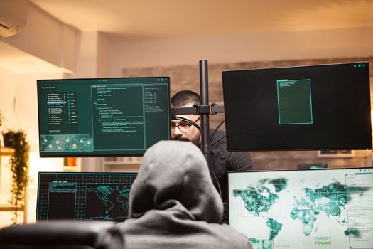 Young hacker talking with cyber terrorist to steal people identity using a dangerous malware.