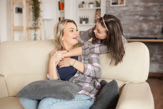 Cheerful mother and daughter looking at each other. Little girl hugging her mother.