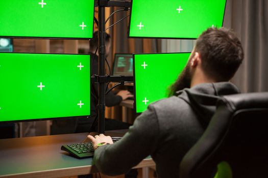 International hacker planning a cyber attack on computer with green chroma key.