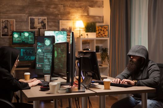 Team of international hackers wearing a hoodie using performance computers.