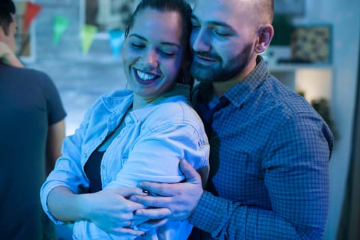 Beautiful young woman having a big smile while dancing with her boyfriend at a party.