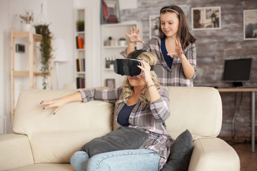 Little girl trying to scare her mother while using virtual headset.