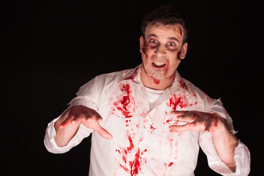 Man with a demon inside his body and blood isolated on black background. Halloween creative makeup.