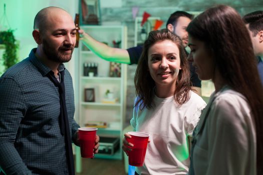 Close friends drinking beer and having a conversation at a party celebrating their friendship