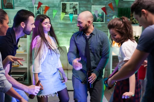 Group of young people celebrating their friendships giving a party in their apartment with good music.