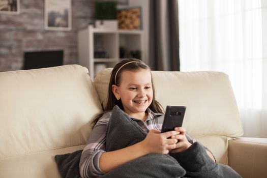 Excited young girl with a big smile and braces browsing on smartphone.