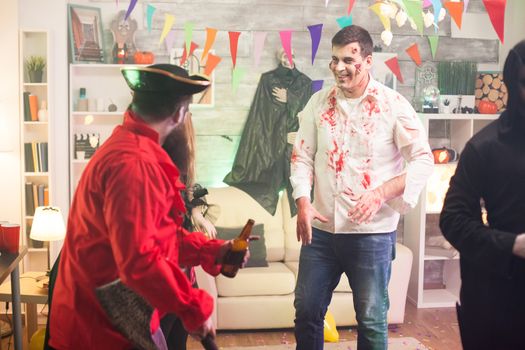 Man dressed up like a scary zombie covered in blood at halloween celebration.