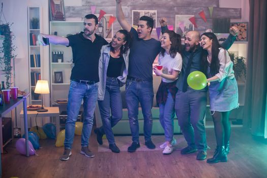 Cheerful man taking a selfie with his excited friends at the party.