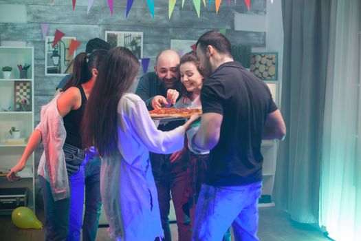 Young girl with pizza for her friends at a party with good music.