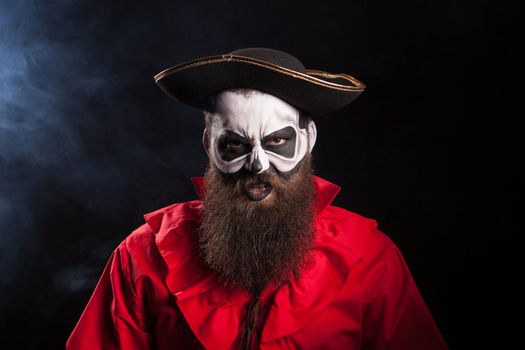 Crazy man dressed up like a pirate isolated on black background. Attractive captain.