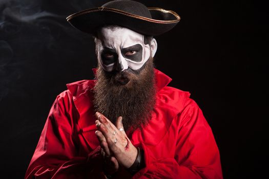 Man dressed up like a scary pirate for halloween celebration over black background.