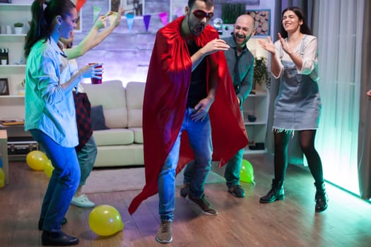 Attractive young man dressed up like a superhero at a party with his friends.