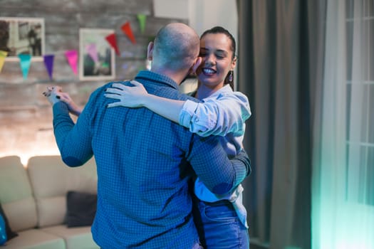 Happy romantic couple having fun in new home dancing.